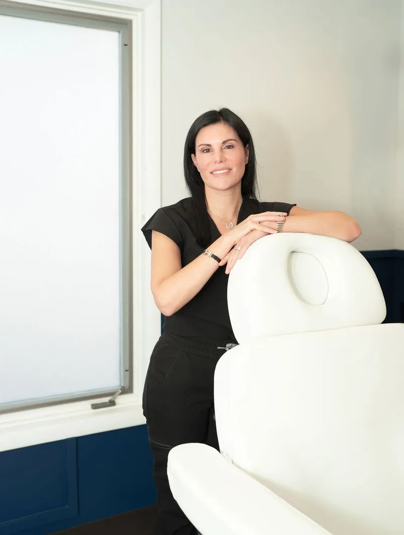 Jennifer Townsley, BSN, RN, standing beside a treatment chair